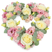 A tender heart-shaped wreath of pastel flowers fills the image, its softly curved outline formed by dozens of carefully placed blooms and sprigs of greenery, like a loving farewell arranged for a service in Great Bookham. The heart is densely packed, so the viewer sees only blossoms and foliage-no gaps, no exposed frame-just a continuous carpet of colour. Cream and pale yellow roses appear throughout, their tightly wound, velvety petals creating luminous centres that stand out gently from the surrounding flowers. Between them, clusters of ruffled pale pink carnations add texture and a sense of comforting softness, as though the surface would feel like a floral cushion to the touch. Scattered among these are slightly deeper, mauve-pink lisianthus, their softly flared, trumpet-like blooms introducing delicate shadows and hints of richer tone within the pastel palette. Tiny yellow-green buds peep through, suggesting freshness and recent, careful preparation, as you might expect from a local Great Bookham florist. Flowing through the design are silvery-green eucalyptus leaves, their round shapes and cool colour tempering the sweetness of the pinks and creams with a serene, almost meditative calm. The wreath sits against a bright white background, which allows every flower and leaf to be clearly distinguished and emphasizes the crisp heart shape. The overall feeling is tender and reverent, ideal as a sympathy tribute, funeral wreath, or memorial arrangement for families in and around Great Bookham, capturing both the sorrow of saying goodbye and the enduring warmth of cherished memories.